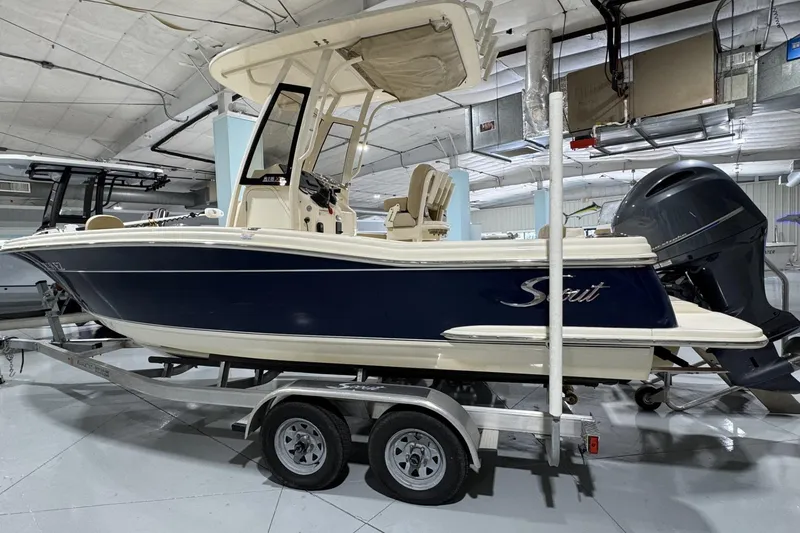 Slide: The Image of 2023 Scout 215 XSF boat on trailer in indoor storage facility. - 1