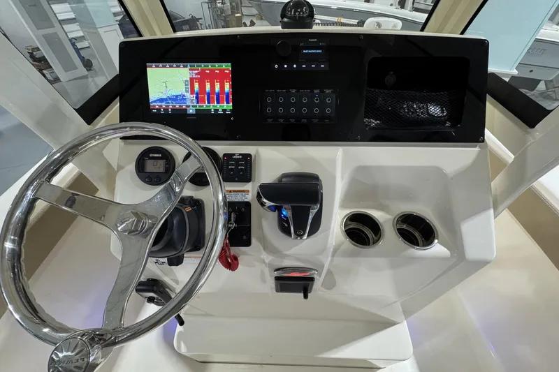 Slide: The Image of 2023 Scout 215 XSF boat dashboard with steering wheel, controls, and navigation display. - 10