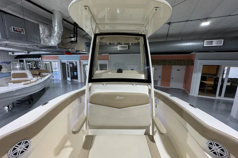 Slide: The Image of 2023 Scout 215 XSF boat interior in showroom, featuring beige seating and modern design. - 12