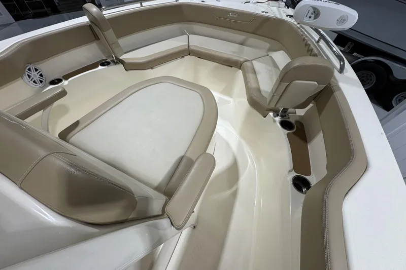 Slide: The Image of 2023 Scout 215 XSF boat interior with beige seating and cup holders. - 13