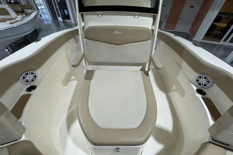 Slide: The Image of 2023 Scout 215 XSF boat interior with beige seating and built-in speakers. - 14