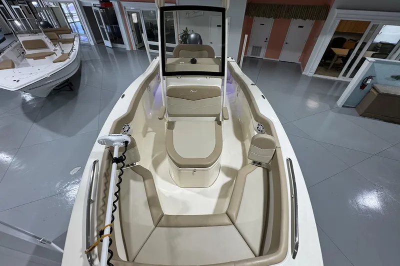 Slide: The Image of 2023 Scout 215 XSF boat interior with beige seating and modern design in showroom. - 15