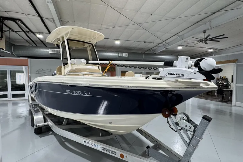 Slide: The Image of 2023 Scout 215 XSF boat on trailer in indoor showroom. - 3