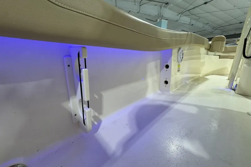 Slide: The Image of 2023 Scout 215 XSF boat interior with blue LED lighting and beige seating. - 6