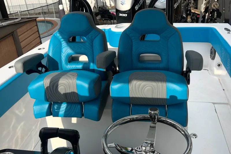 Slide: The Image of 2023 Sea Tech 33 CC boat cockpit with blue and gray cushioned seats and steering wheel. - 4