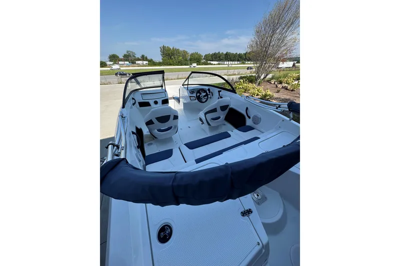 Slide: The Image of 2018 Tahoe 450TS boat interior with seating and steering wheel, parked outdoors. - 4