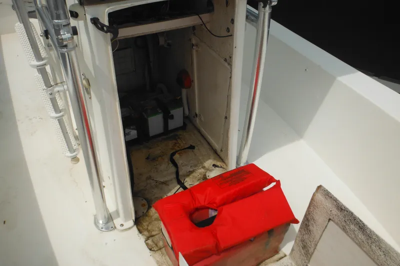 Slide: The Image of 2006 DC 23 Brown Custom CC boat interior with battery compartment and red life jacket. - 32