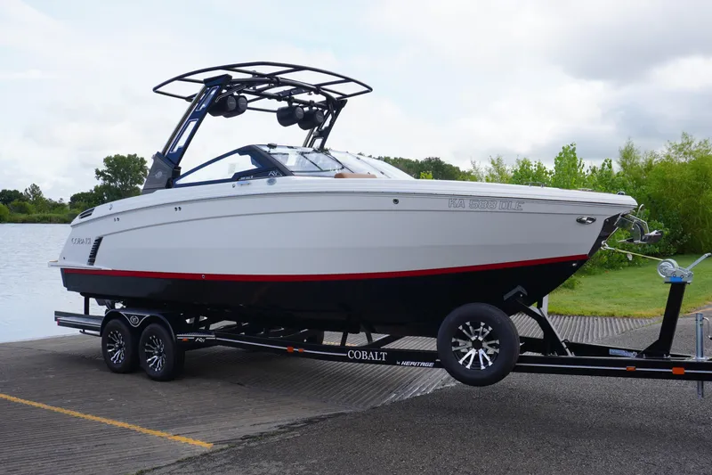 Slide: The Image of 2025 Cobalt R8 Surf boat on trailer by a lake, ready for launch. - 1