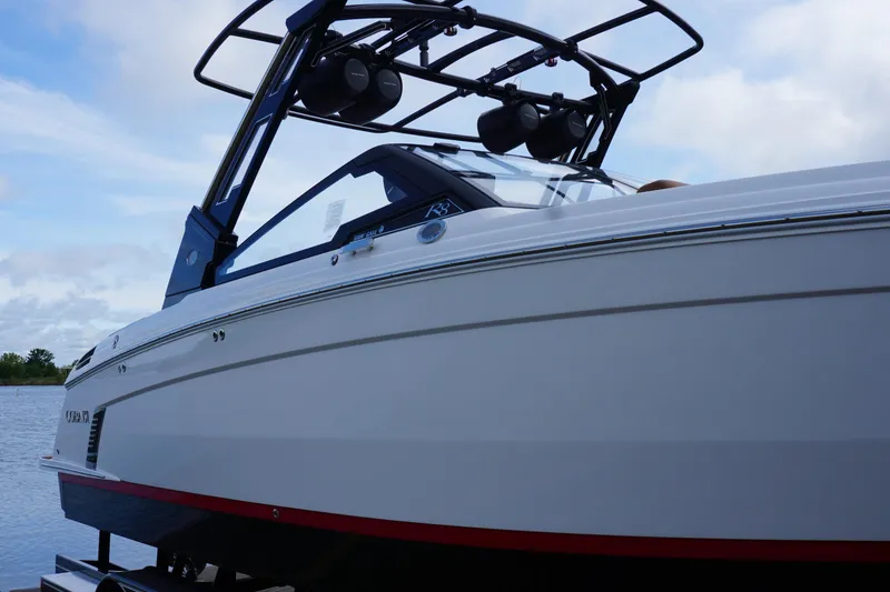 Slide: The Image of 2025 Cobalt R8 Surf boat on water, sleek design with modern features. - 2