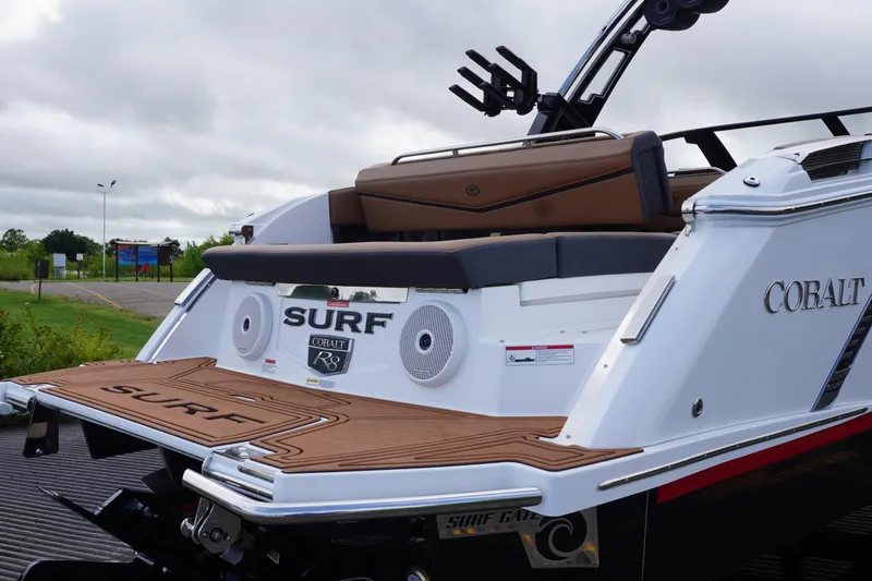Slide: The Image of 2025 Cobalt R8 Surf boat with sleek design and premium seating on a cloudy day. - 4
