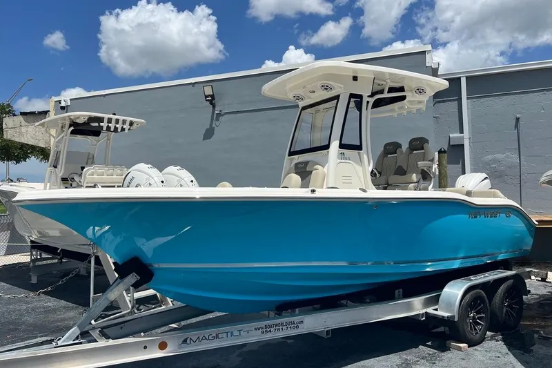 The Image of 2026 Key West 219 FS boat on trailer, vibrant blue hull, sunny day. - 0