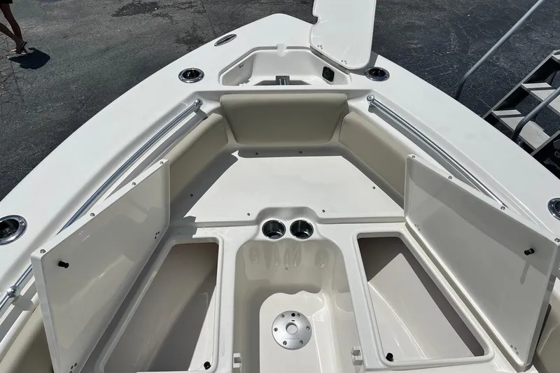 Slide: The Image of 2026 Key West 219 FS boat interior with open storage compartments and cup holders. - 13