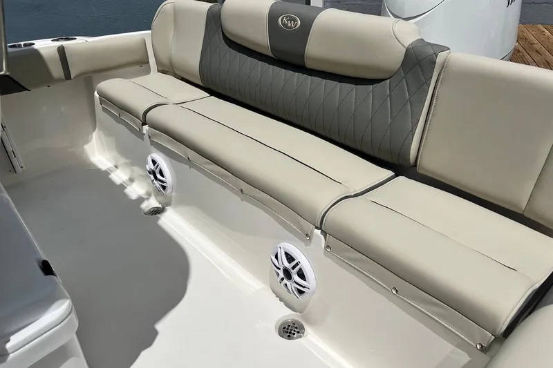 Slide: The Image of 2026 Key West 219 FS boat interior with beige cushioned seating and built-in speakers. - 16