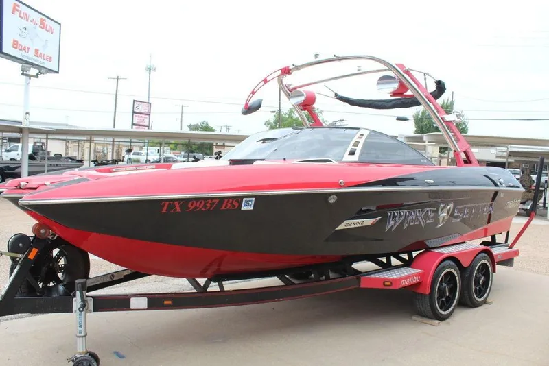 Slide: The Image of 2012 Malibu Wakesetter 22 MXZ boat in red and black on trailer. - 5