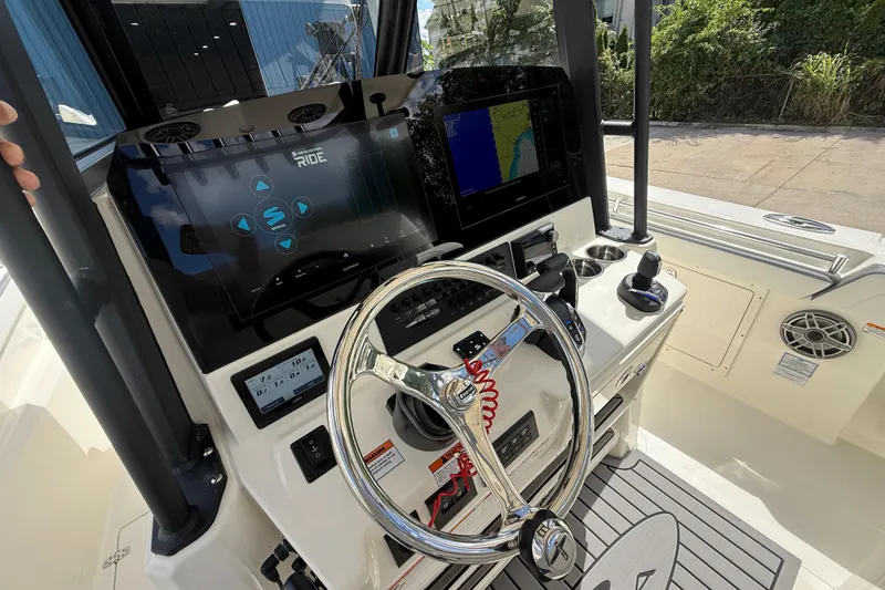 Slide: The Image of 2026 Cobia 305 Center Console boat dashboard with advanced navigation system and steering wheel. - 18