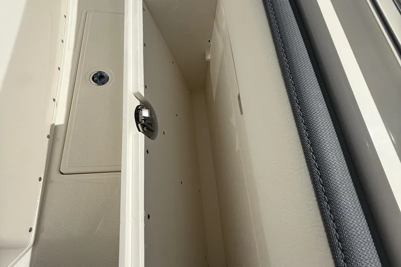 Slide: The Image of Storage compartment on a 2026 Cobia 305 Center Console boat, featuring secure latch. - 22