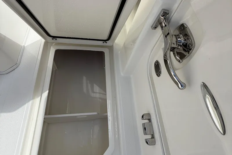 Slide: The Image of 2026 Cobia 305 Center Console storage compartment with chrome handle detail. - 37