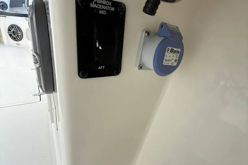 Slide: The Image of 2026 Cobia 305 Center Console boat interior with fishbox macerator and electrical outlet. - 38