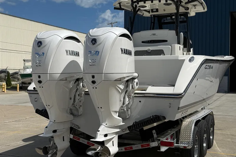 Slide: The Image of 2026 Cobia 305 Center Console boat with dual Yamaha 350 engines on a trailer. - 4