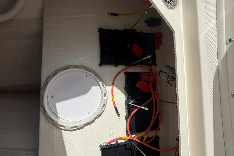 Slide: The Image of 2026 Cobia 305 Center Console battery compartment with wiring and access panel. - 40