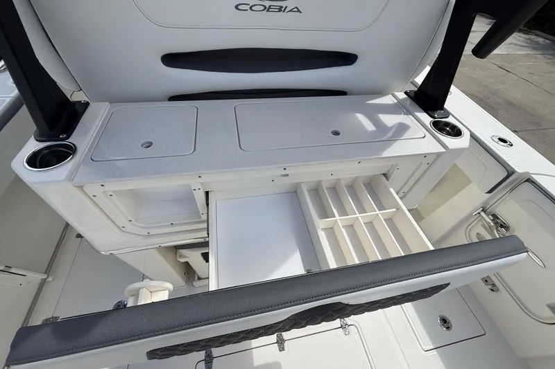 Slide: The Image of 2026 Cobia 305 Center Console boat with open storage compartments and cup holders. - 41