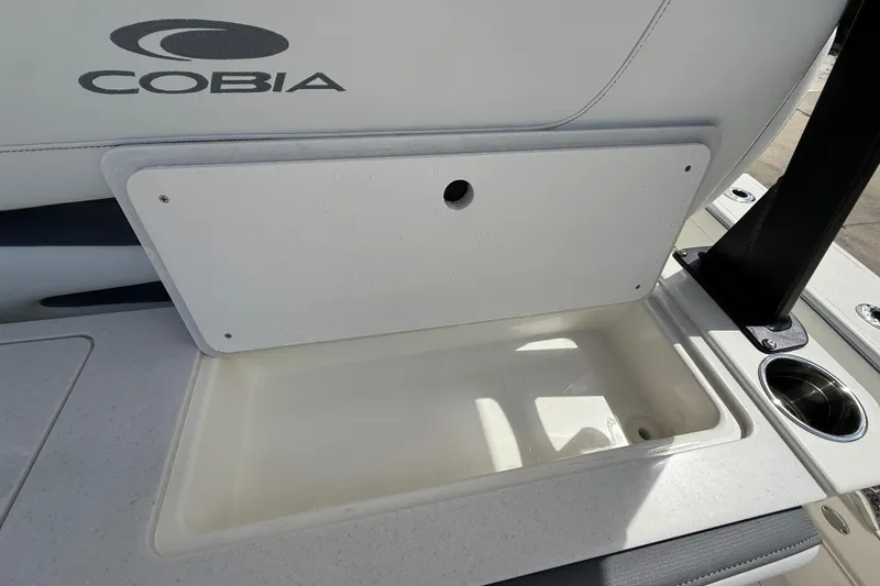 Slide: The Image of Cobia 305 Center Console 2026 boat storage compartment with cup holder. - 42