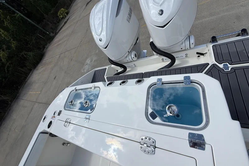 Slide: The Image of 2026 Cobia 305 Center Console boat with dual outboard engines and sleek deck design. - 44