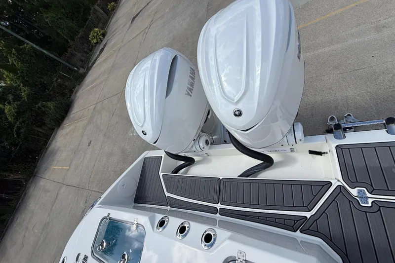 Slide: The Image of 2026 Cobia 305 Center Console with dual Yamaha outboard engines, docked on concrete. - 45