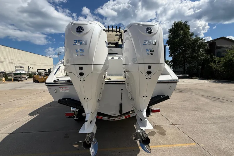 Slide: The Image of 2026 Cobia 305 Center Console with twin Yamaha 350 V6 engines, parked outdoors. - 8