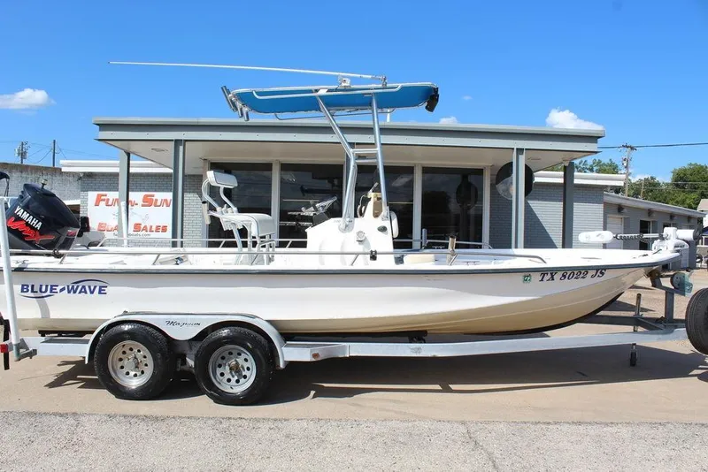 Slide: The Image of 2002 Blue Wave 2200 DELUXE CC boat on trailer, parked outside dealership. - 1
