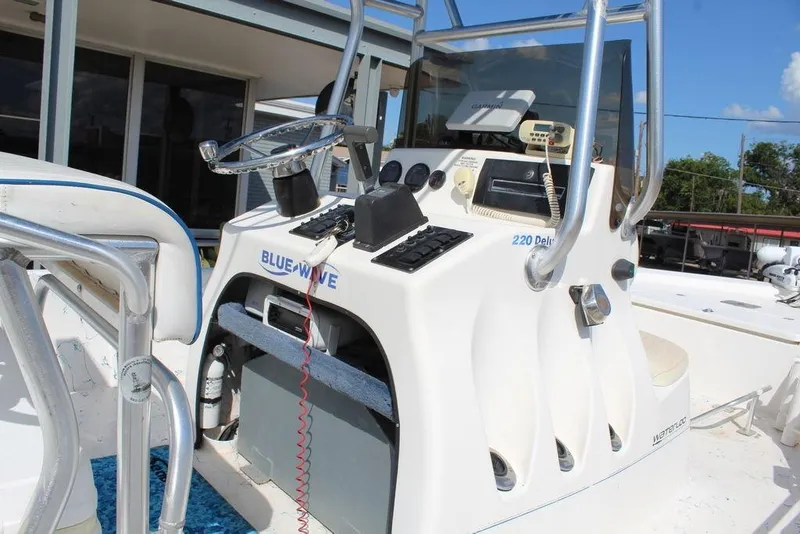 Slide: The Image of 2002 Blue Wave 2200 Deluxe CC boat console with steering wheel and controls. - 10