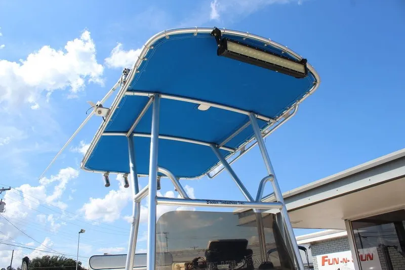 Slide: The Image of Blue Wave 2200 DELUXE CC boat with blue canopy under clear sky, 2002 model. - 12