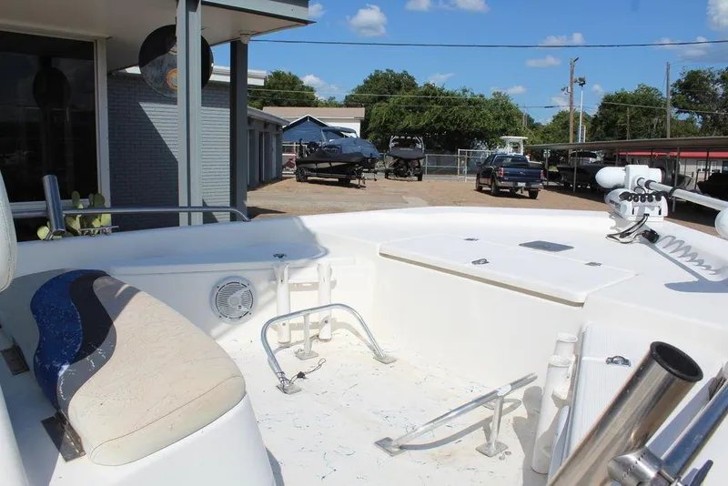 Slide: The Image of 2002 Blue Wave 2200 DELUXE CC boat interior with seating and equipment, parked outdoors. - 13