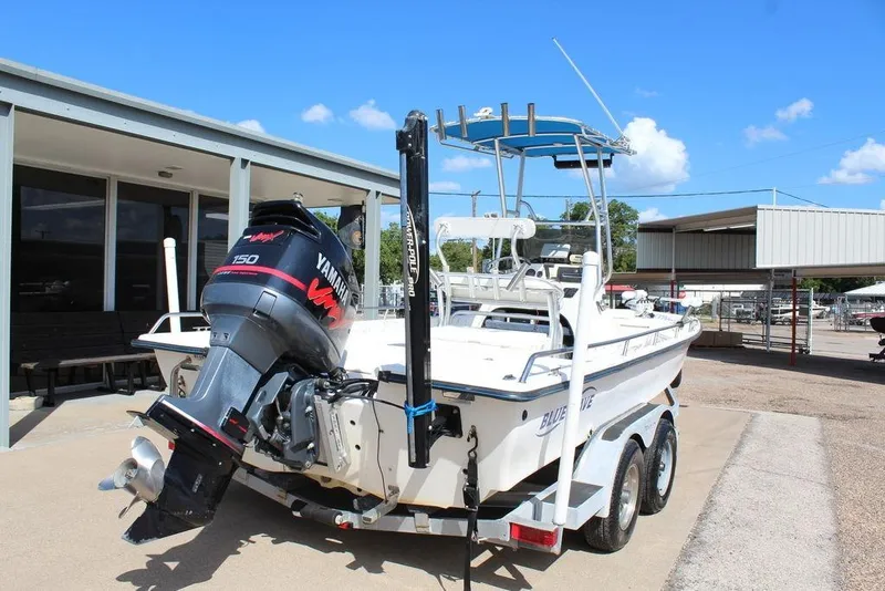 Slide: The Image of 2002 Blue Wave 2200 DELUXE CC boat with Yamaha engine on trailer, parked outdoors. - 3