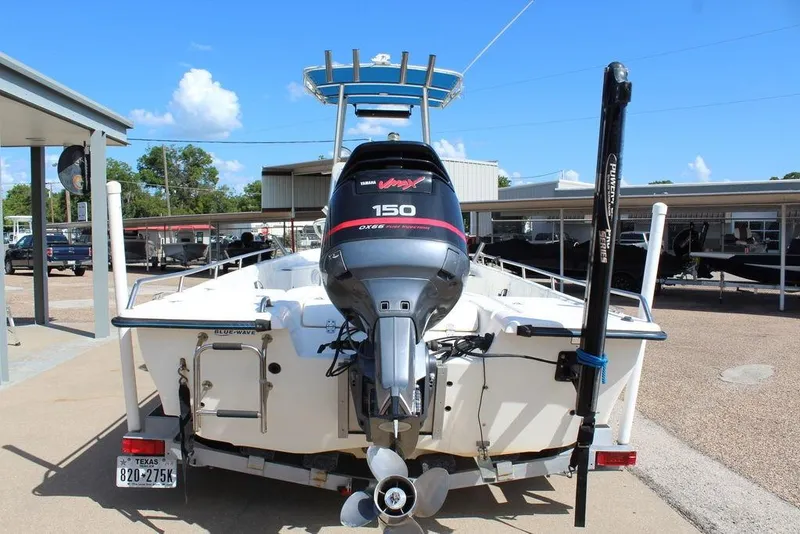 Slide: The Image of 2002 Blue Wave 2200 DELUXE CC boat with Yamaha 150 engine, parked outdoors. - 9