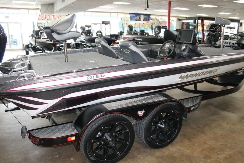 Slide: The Image of 2024 Phoenix 921 ELITE bass boat in showroom, featuring sleek design and advanced features. - 2