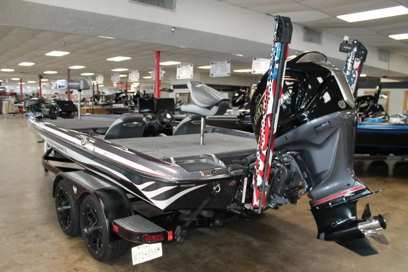 Slide: The Image of 2024 Phoenix 921 ELITE bass boat in showroom, featuring sleek design and powerful outboard motor. - 7