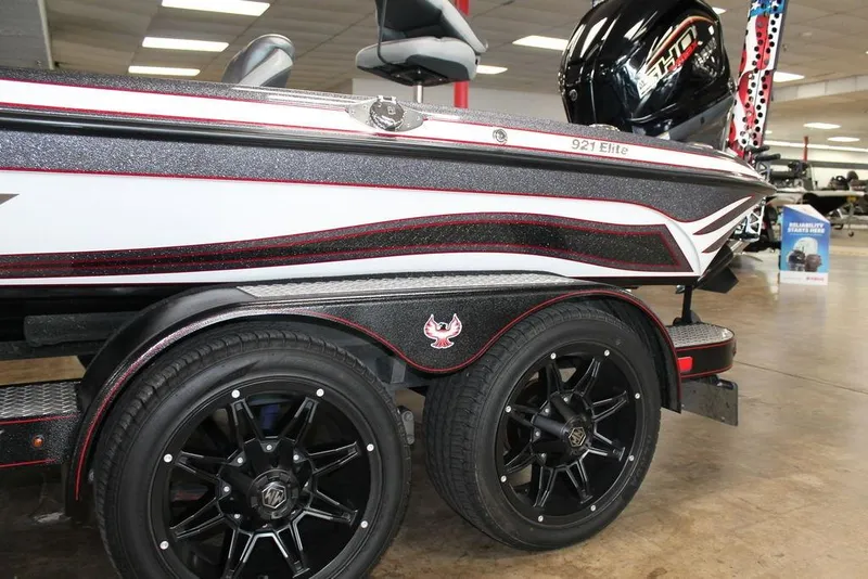 Slide: The Image of 2024 Phoenix 921 ELITE boat with sleek design and black wheels in showroom. - 8