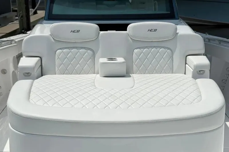 Slide: The Image of Luxurious white seating on 2025 HCB 48 Campeon boat, featuring diamond stitching and cup holder. - 16
