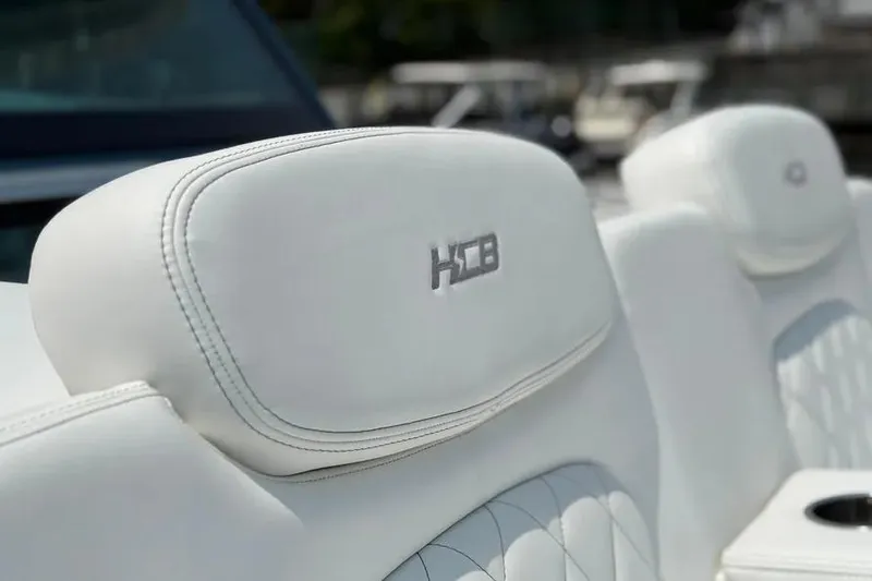 Slide: The Image of White leather seats on 2025 HCB 48 Campeon boat, featuring embroidered logo. - 17