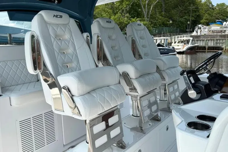 Slide: The Image of Luxurious seating on 2025 HCB 48 Campeon boat, featuring white quilted leather and chrome accents. - 37