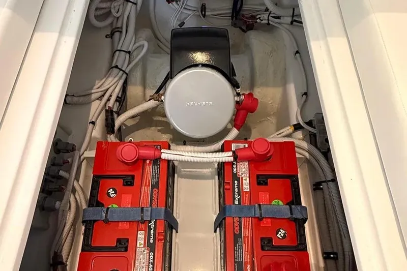 Slide: The Image of 2025 HCB 48 Campeon boat engine compartment with red batteries and wiring. - 49