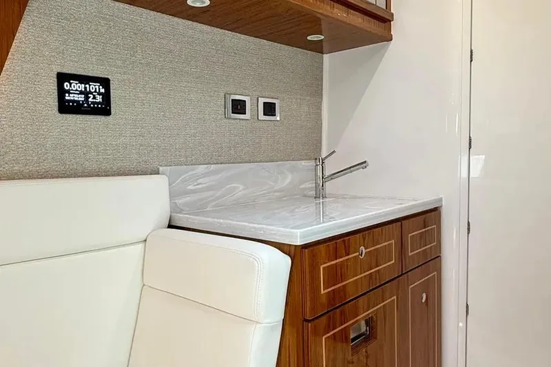 Slide: The Image of Interior of 2025 HCB 48 Campeon yacht featuring a sleek kitchenette with wood cabinetry. - 51