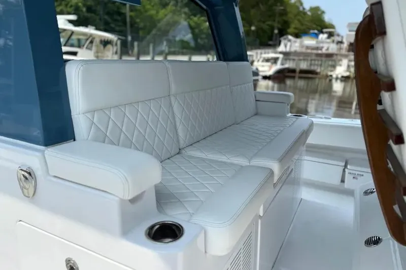Slide: The Image of Luxurious white seating on 2025 HCB 48 Campeon boat, docked at marina. - 56