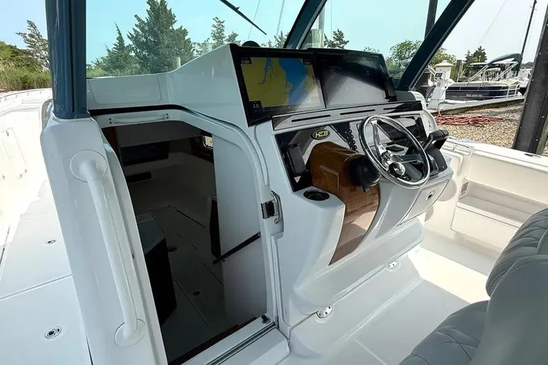 Slide: The Image of 2025 HCB 48 Campeon boat cockpit with steering wheel and navigation screens. - 73