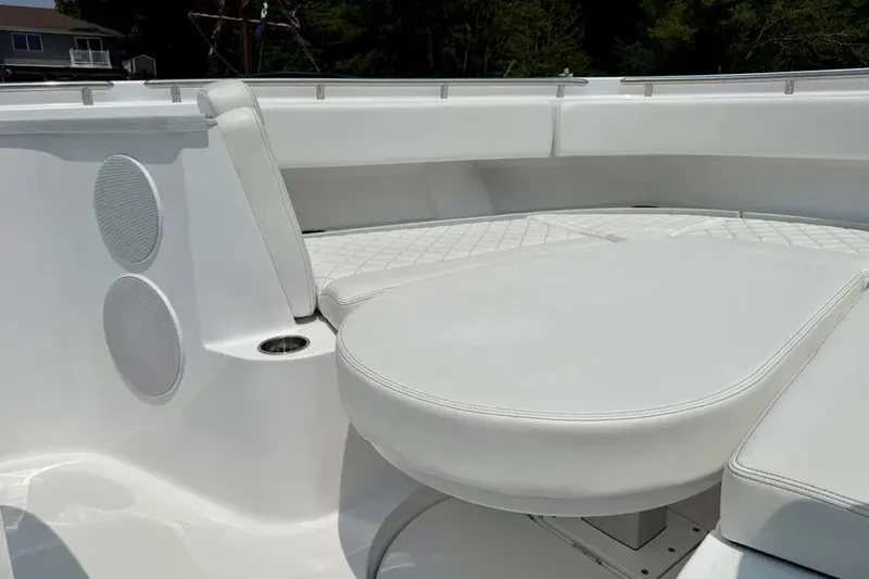 Slide: The Image of Luxurious seating on 2025 HCB 48 Campeon boat, featuring white upholstery and speakers. - 9