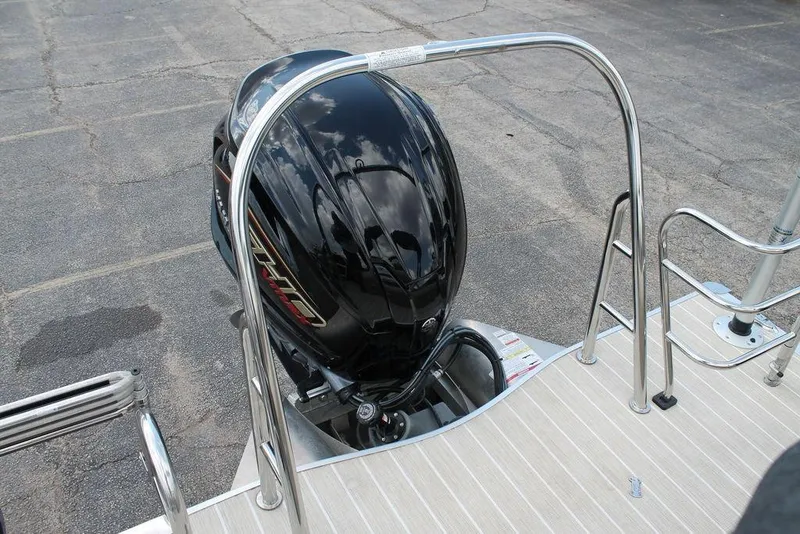 Slide: The Image of 2023 Trifecta 24UL-CS boat with a sleek black outboard motor and stainless steel railings. - 10