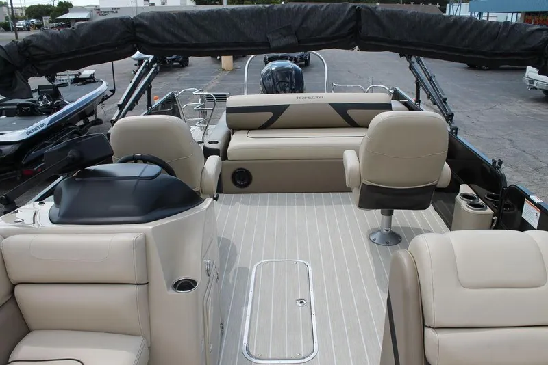 Slide: The Image of 2023 Trifecta 24UL-CS pontoon boat interior with beige seating and steering console. - 14