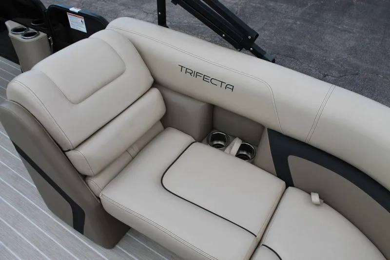 Slide: The Image of 2023 Trifecta 24UL-CS boat seating with beige upholstery and cup holders. - 16