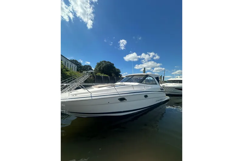 Slide: The Image of 2014 Regal 35 Sport Coupe boat docked under a clear blue sky. - 6